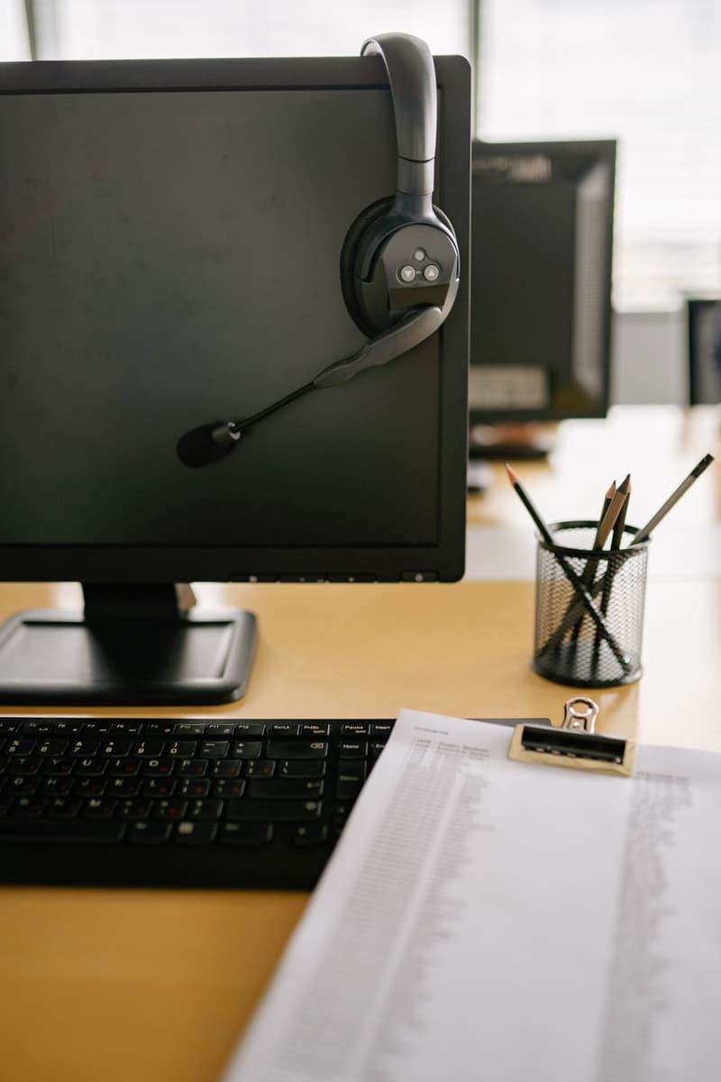 Monitor da ufficio con cuffie per assistenza clienti appese allo schermo