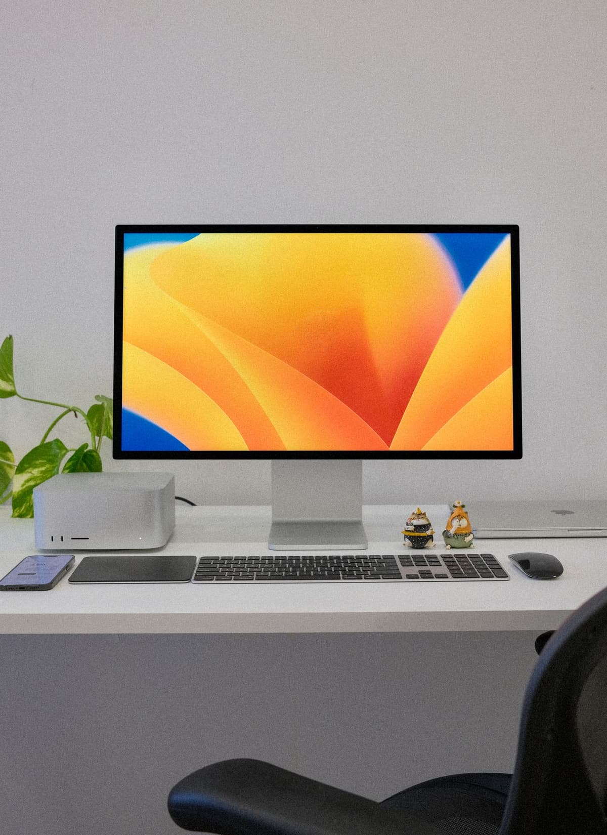 Postazione desktop moderna con monitor, tastiera e accessori su una scrivania minimale