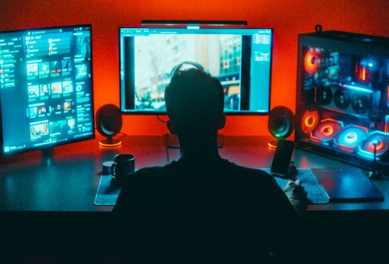 Postazione da gioco con più monitor e illuminazione ambientale rossa