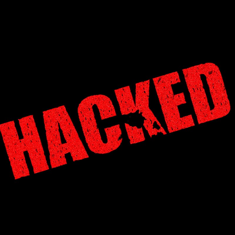 Timbro rosso con la scritta HACKED, a simboleggiare una violazione informatica avvenuta