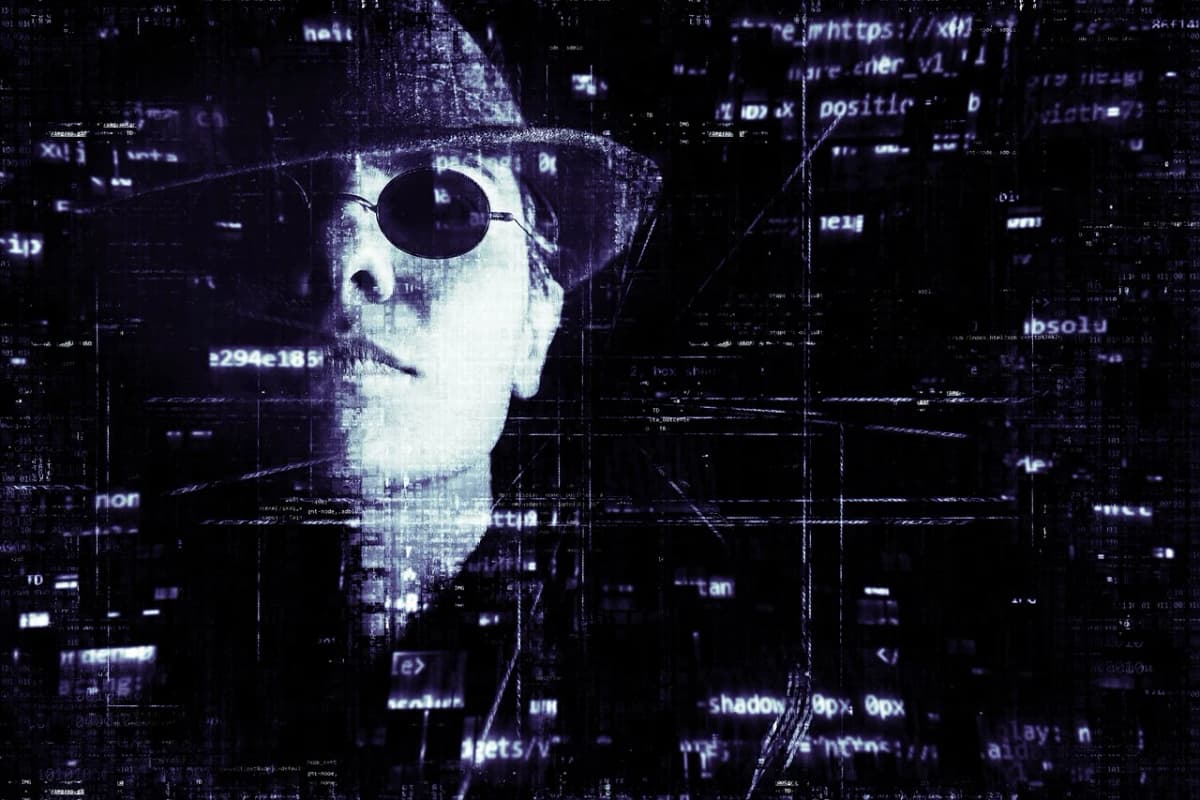 Illustrazione digitale di un volto parzialmente distorto, con cappello e occhiali scuri, sovrapposto a frammenti di codice e indirizzi web